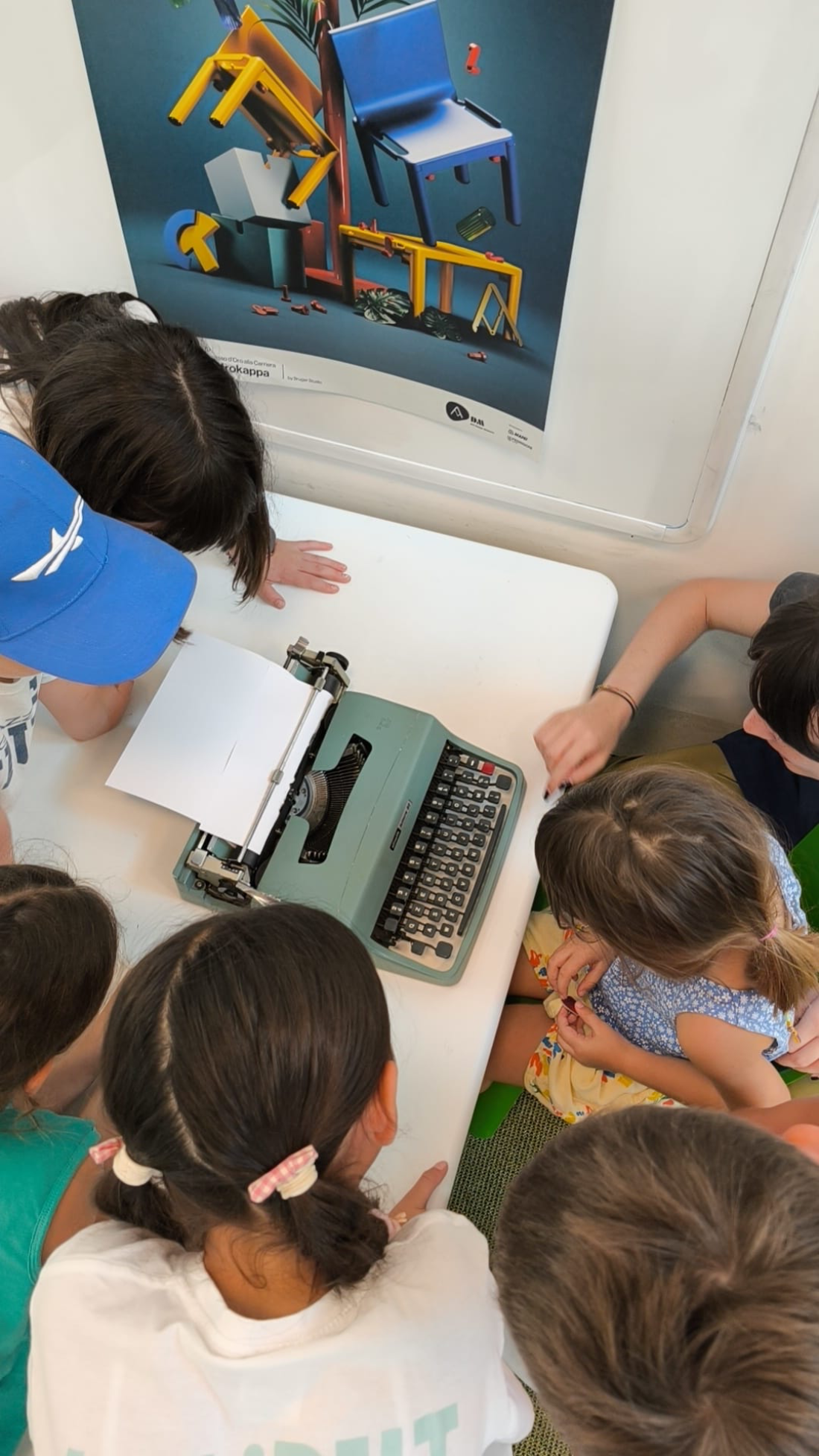 Bambini intorno a una macchina da scrivere Olivetti durante un corso pomeridiano